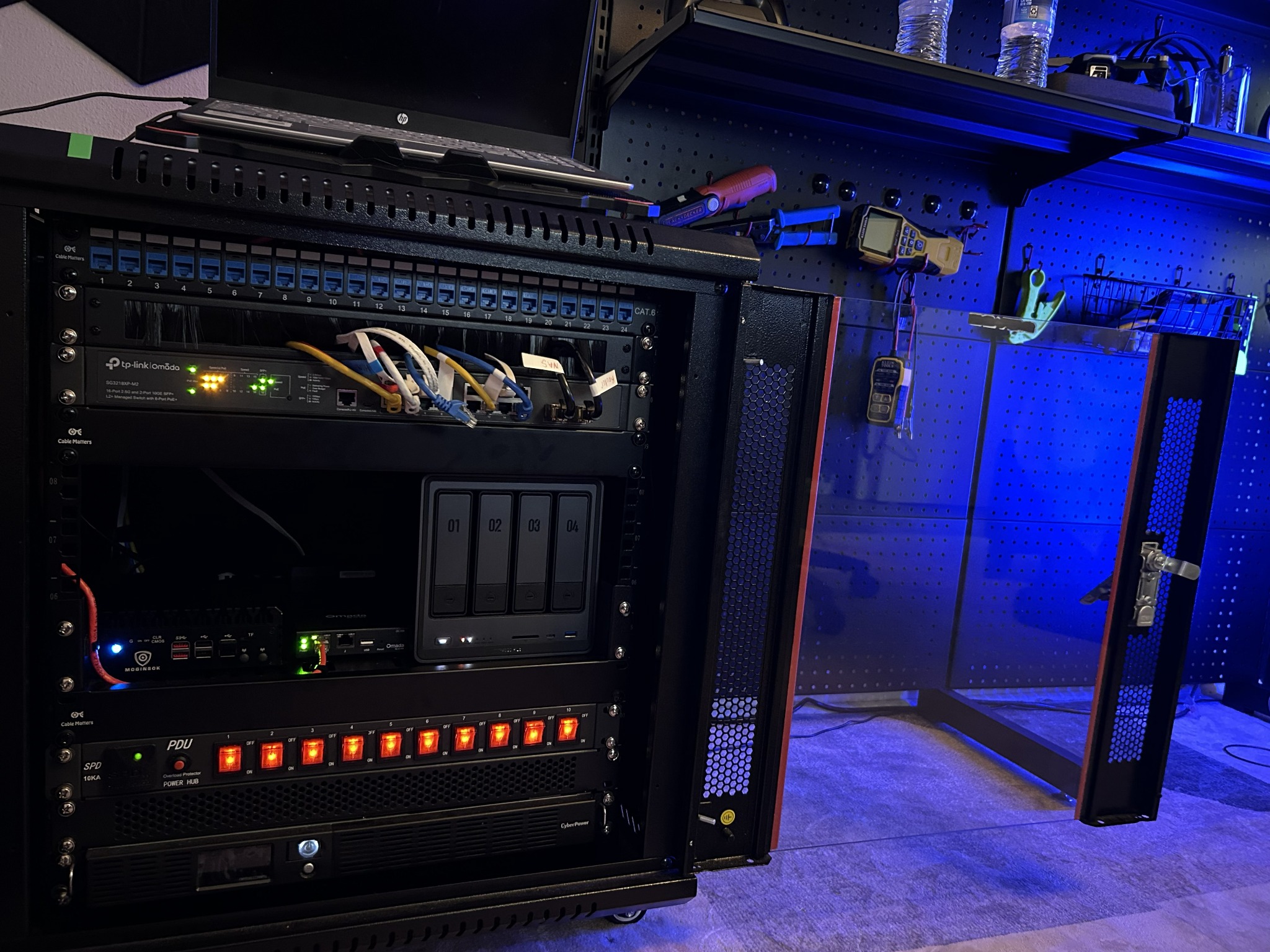 Completed home-lab network rack with firewall, switching, NAS, UPS, PDU, and patch cabling